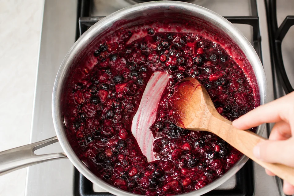 Crushed berries simmering until the syrup leaves a clear trail behind the spoon.