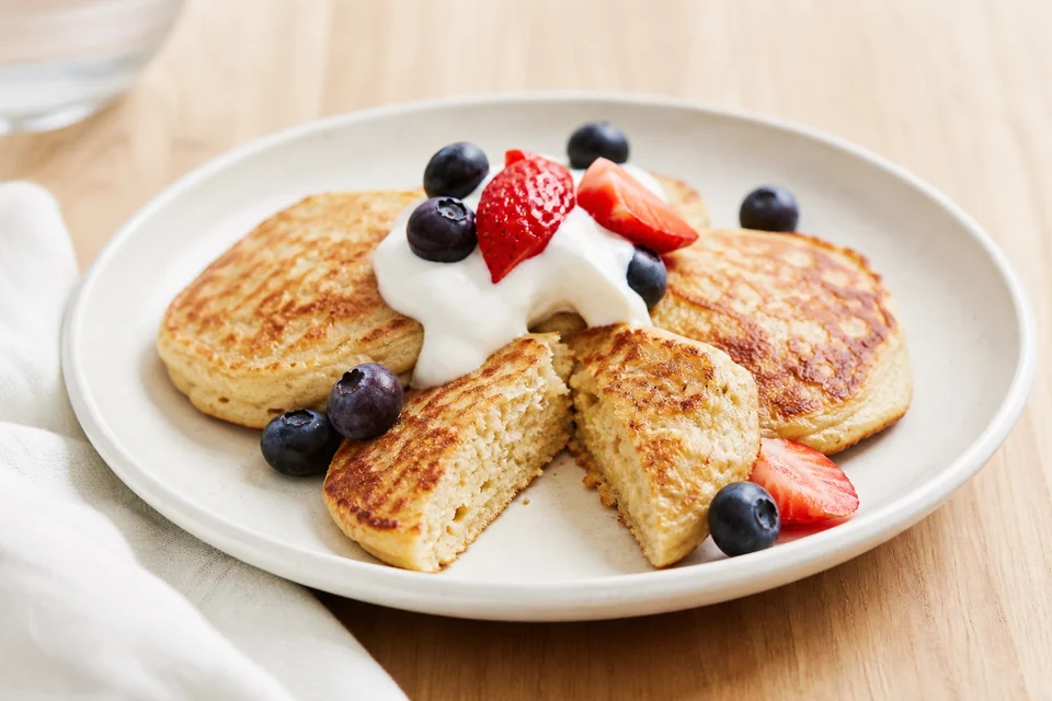 Finished three-ingredient protein pancakes with yogurt, berries, and a fully cooked cut centre