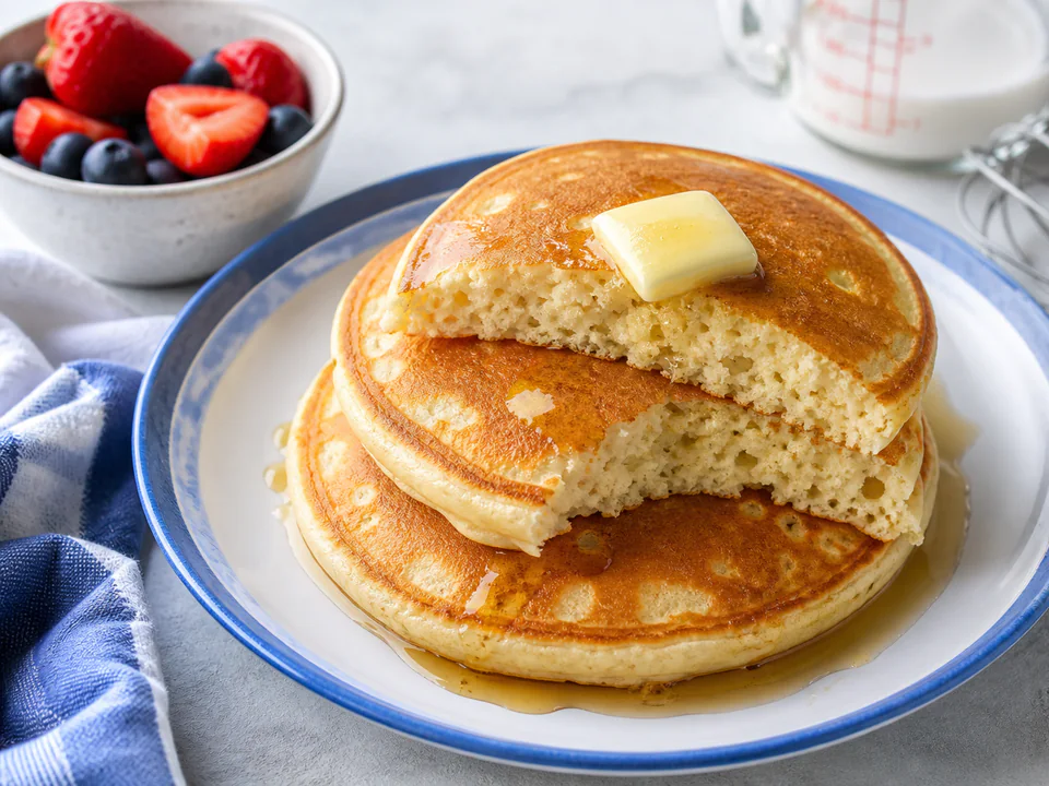 Close detail of an evenly browned fluffy pancake and its open cooked crumb